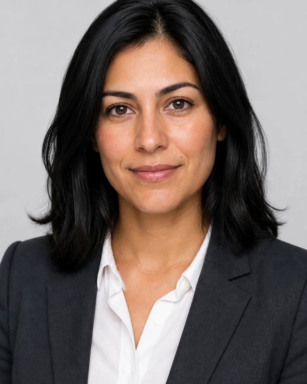Professional headshot of a woman on a light grey studio background