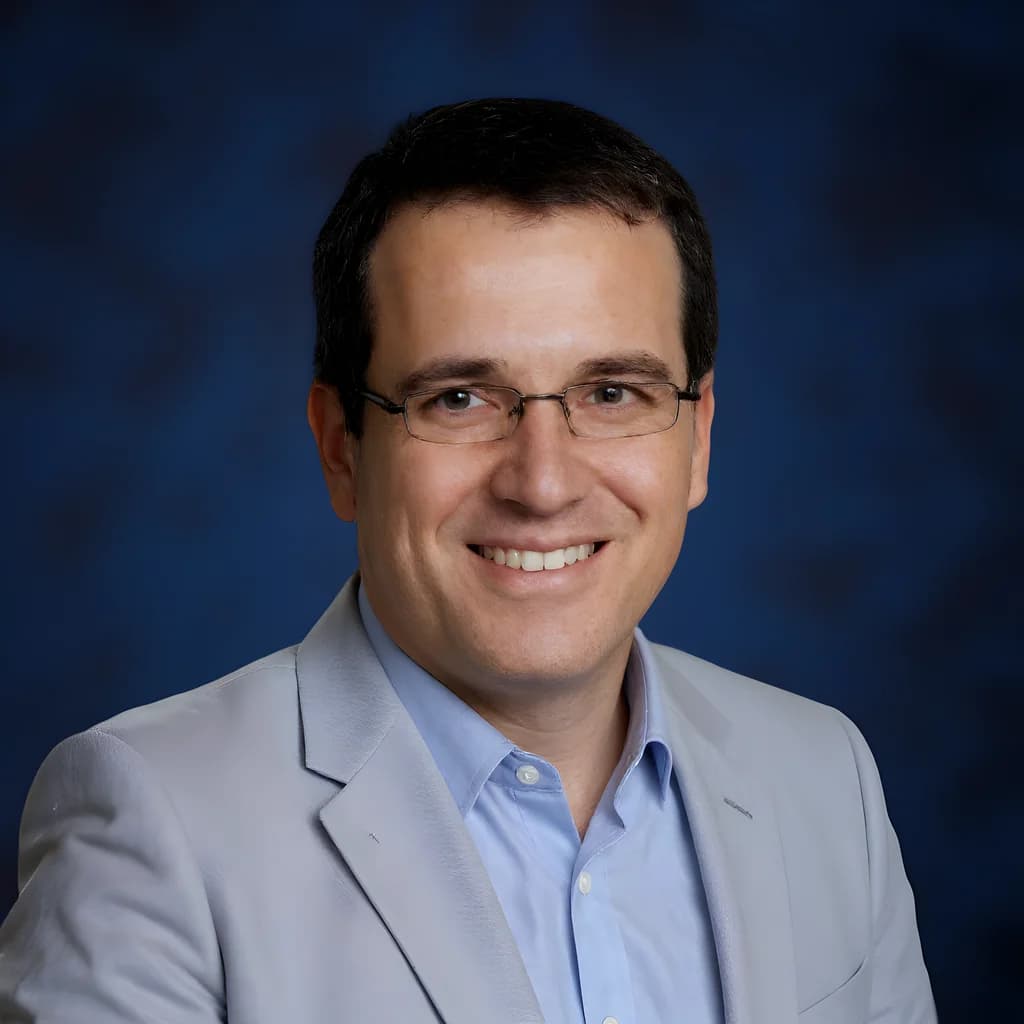 Professional headshot on a solid navy blue background